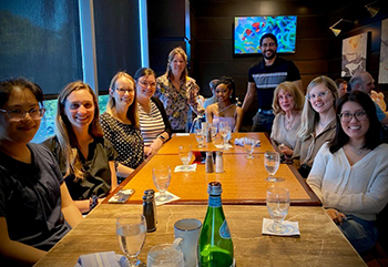 2023 graduates sitting around a table during their graduation dinner