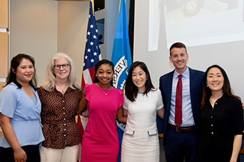 Graduates standing in a group and smiling at the 2023 Tufts Graduation