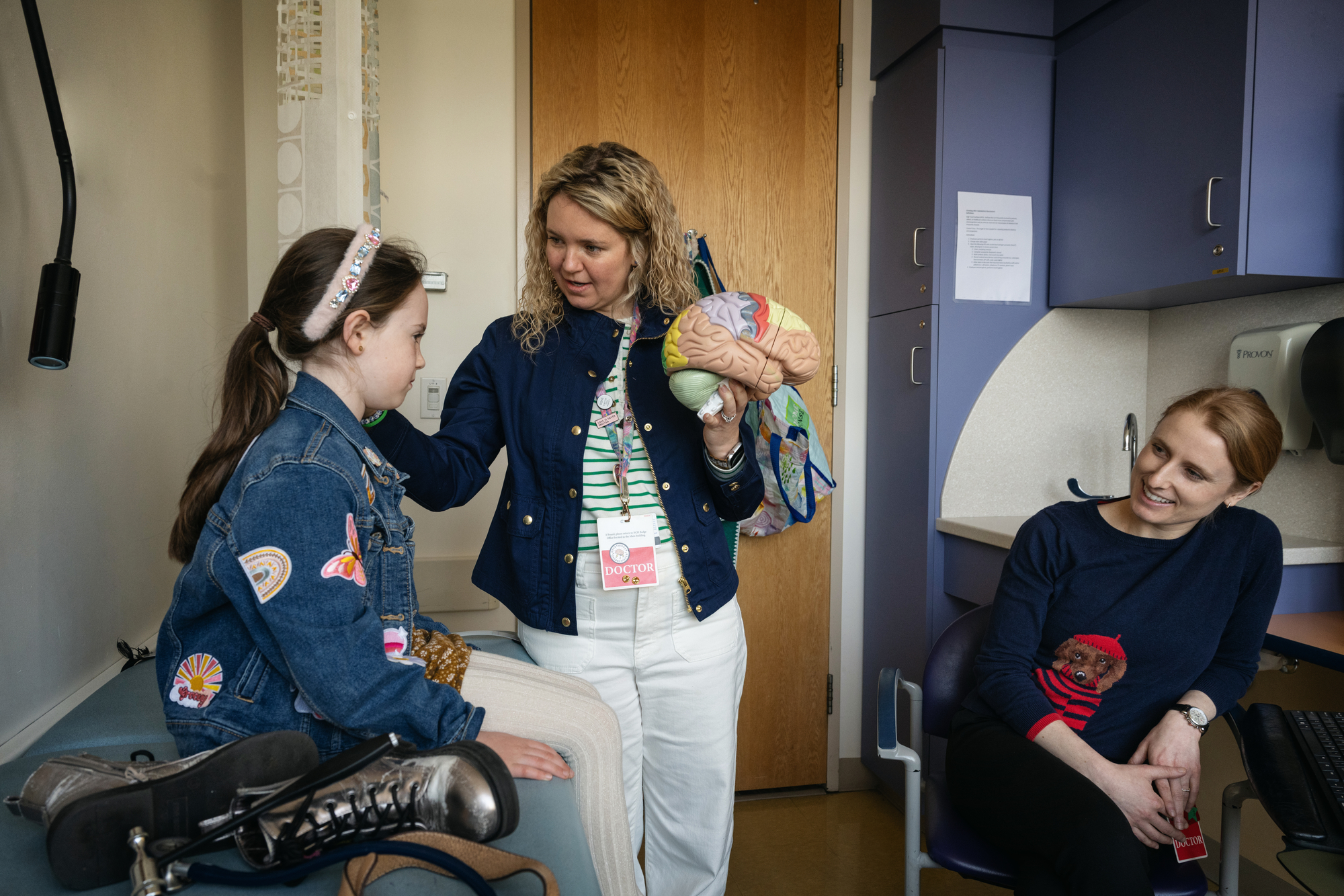 Neurologists interact with patient in a clinical exam room.