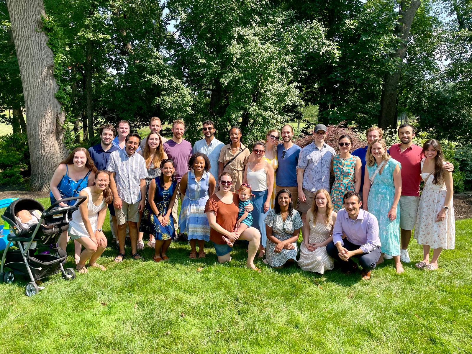 Group of neurology residents and fellows standing in a group and smiling at a park