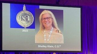 Photo of Shelley Klein on a projector screen during an awards ceremony
