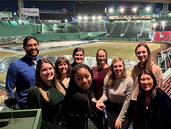 2023 class standing in a group and smiling at Fenway Park