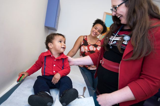 Dr. Laura Lehman with patient and their parent in clinic room