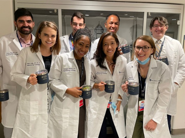 Group photo of Pediatric Cardiology Fellows holding mugs and wearing white coats