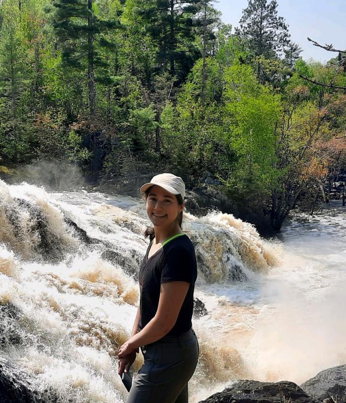 Chandra Swanson in front of a fast-flowing river
