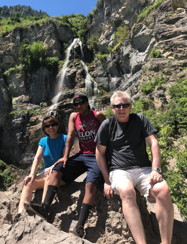 Gary Visner with family on a hiking trail in front of a waterfall
