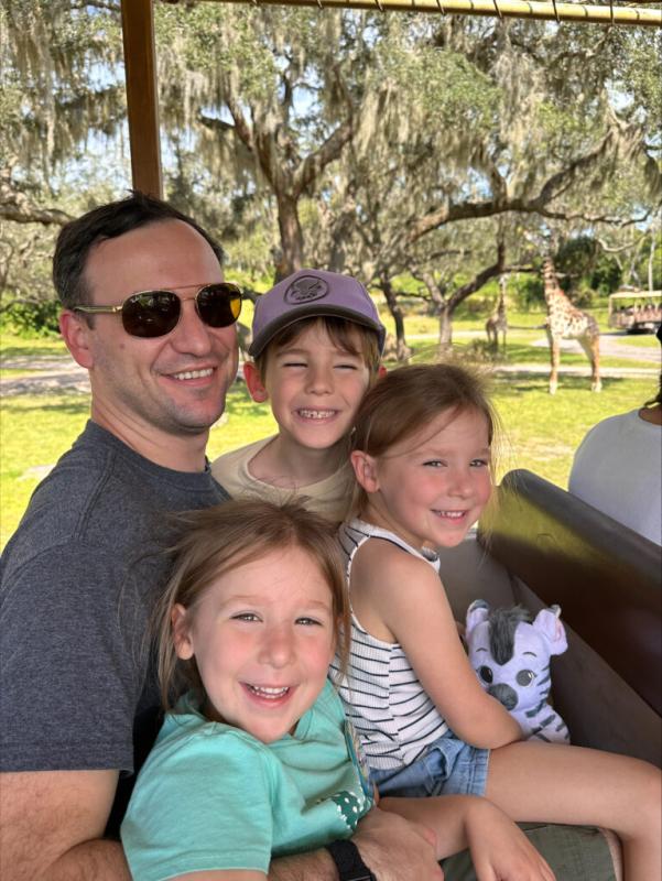 Gabriel Paris sitting with three smiling children