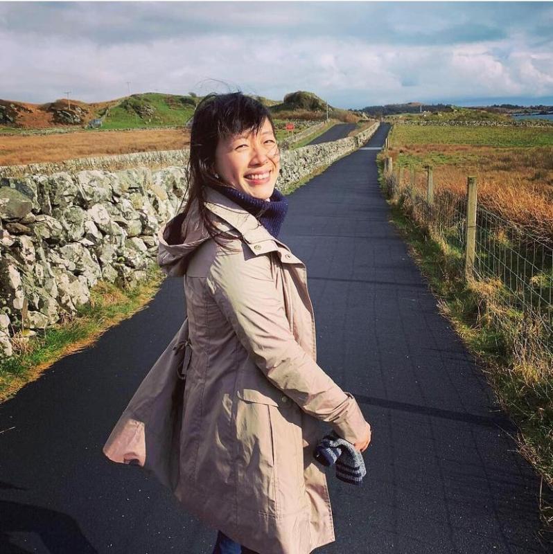 Julia Lee on a sidewalk through farmland